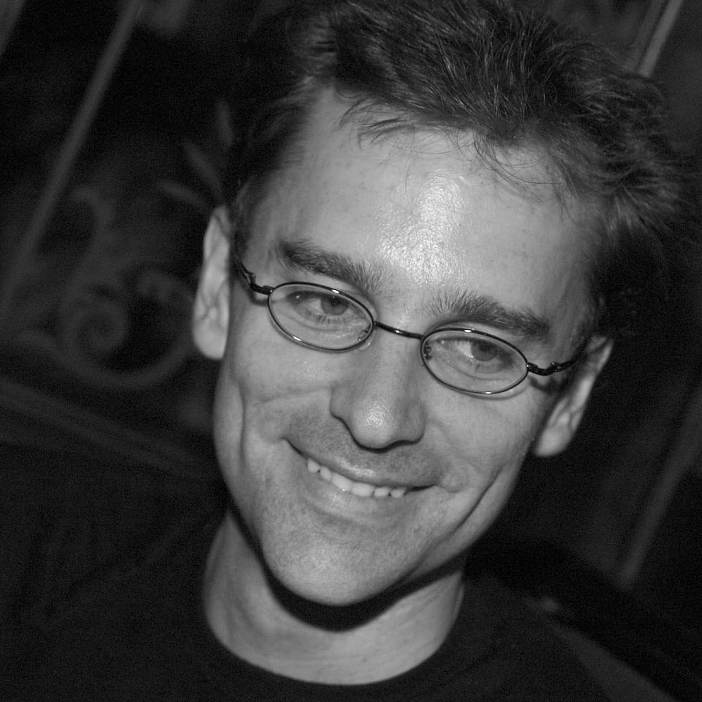 a man wearing glasses smiling