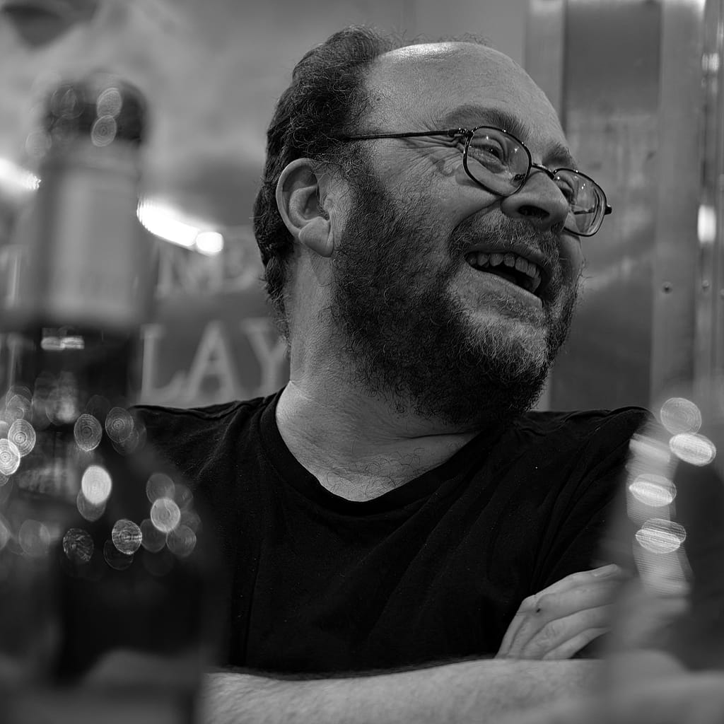 a man with beard and glasses smiling
