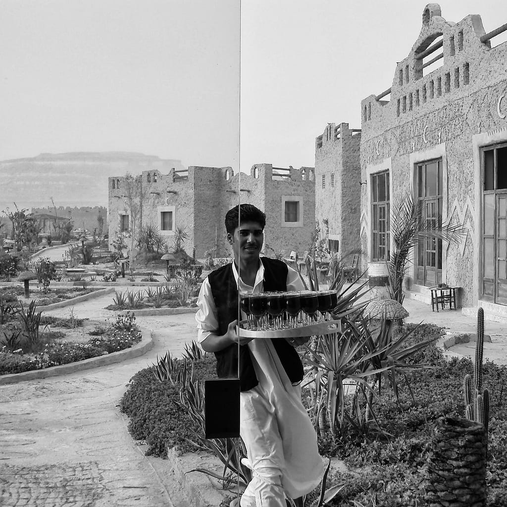Egypt Eclipse Tour A waitier brings a Tray of Drinks at the Oasis Hotel (Black and White)