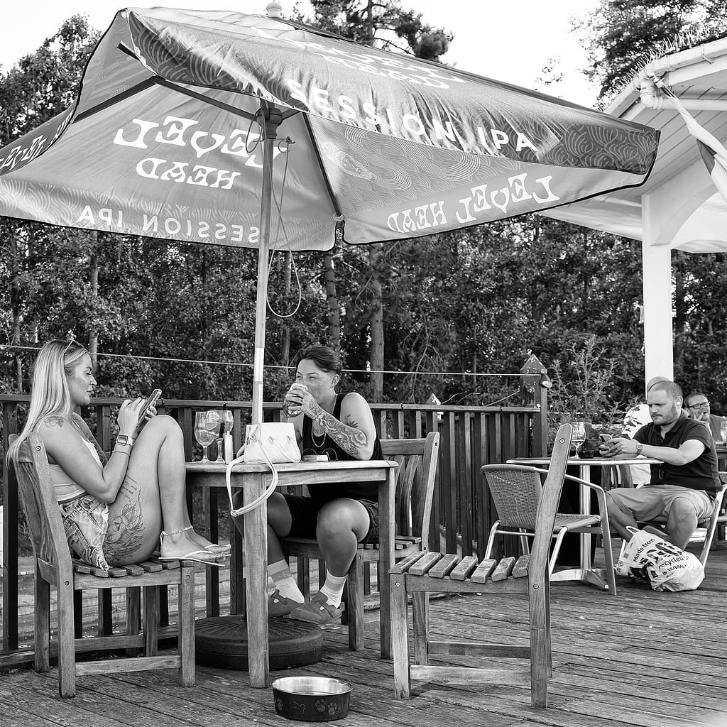 a group of people sitting at a table under an umbrella