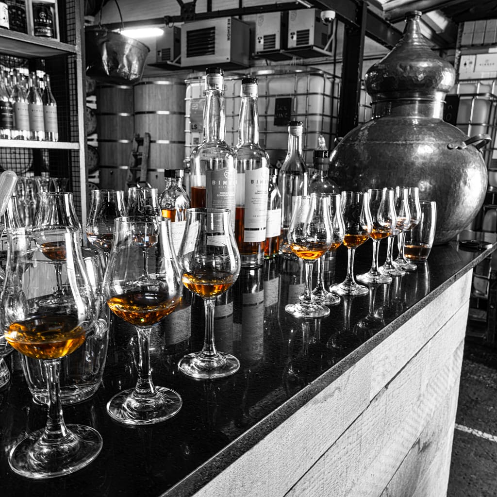 A Row of whisky glasses and bottles
