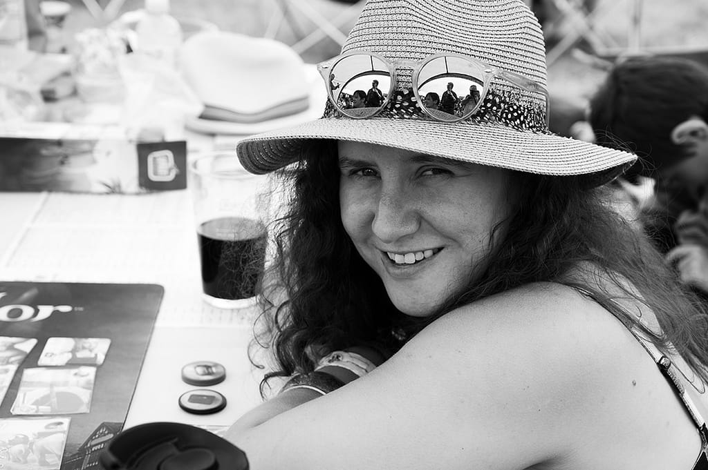 A woman in a sunhat has turned to smile at the camera