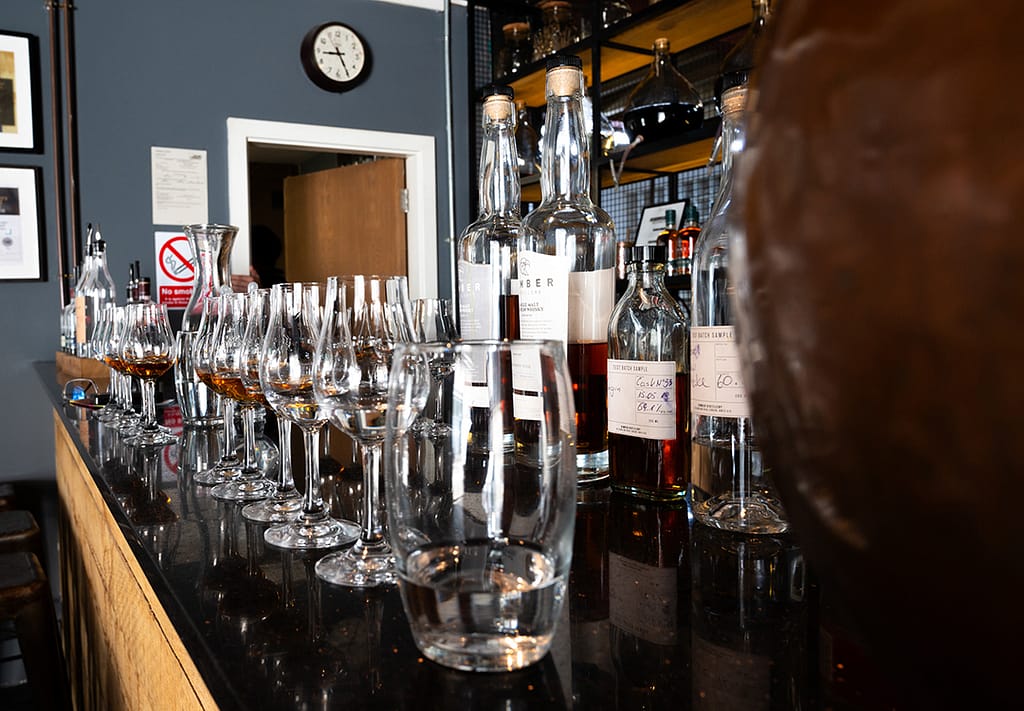 Glasses of whisky lined up on a bar, ready for tasting