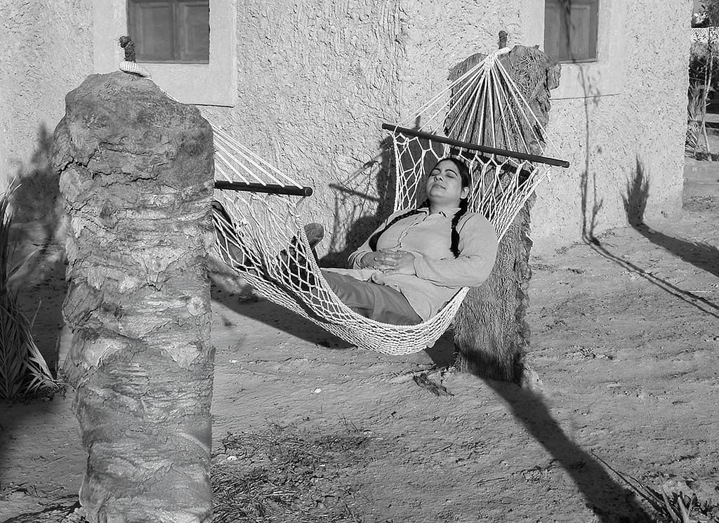 A woman lies back in a hammock in the heat of the Egyptian sun