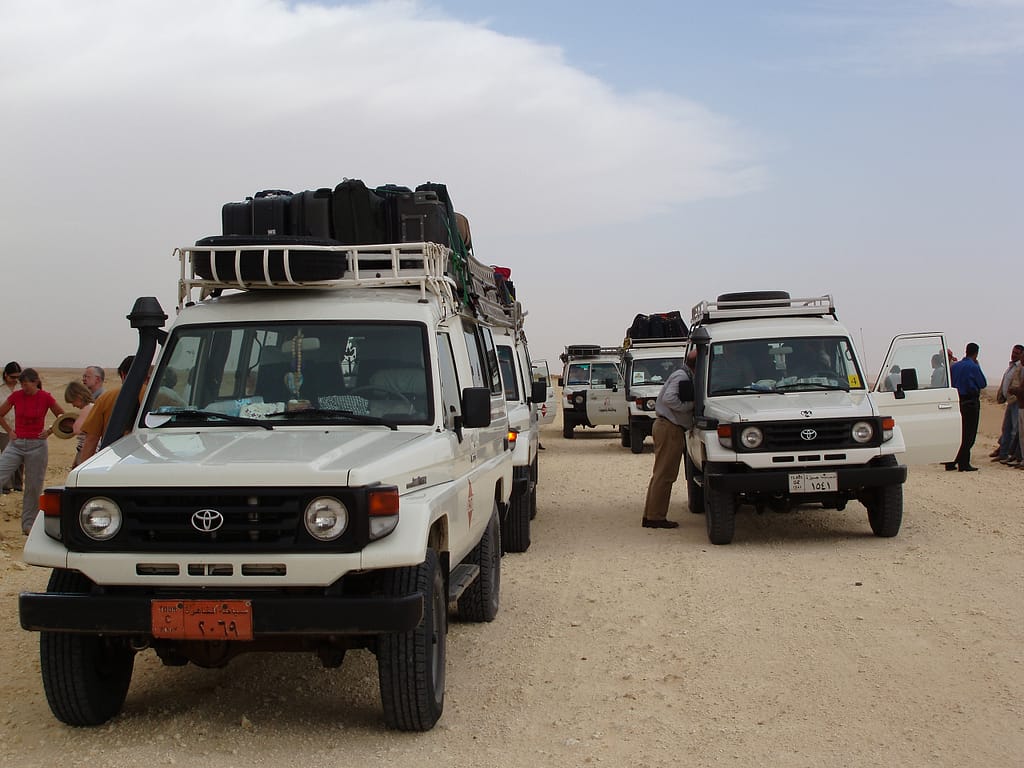 Egypt Eclipse Tour a group of white vehicles with luggage on top