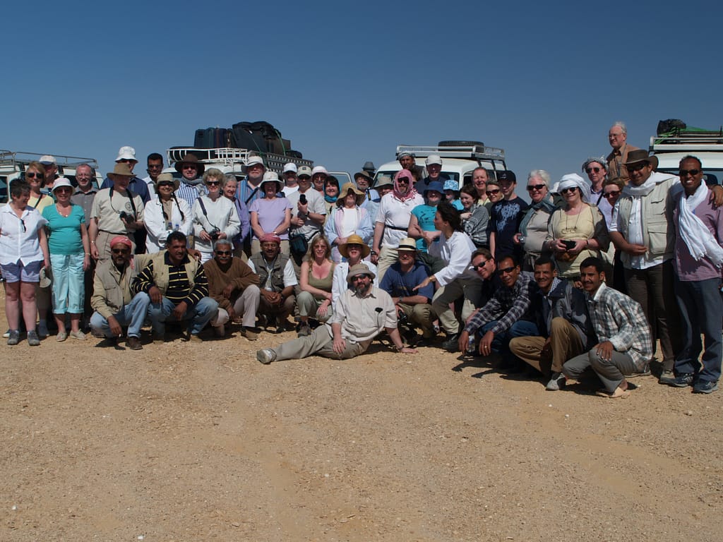 Egypt Eclipse Tour -a group of people posing for a photo with Landcruiser in the background