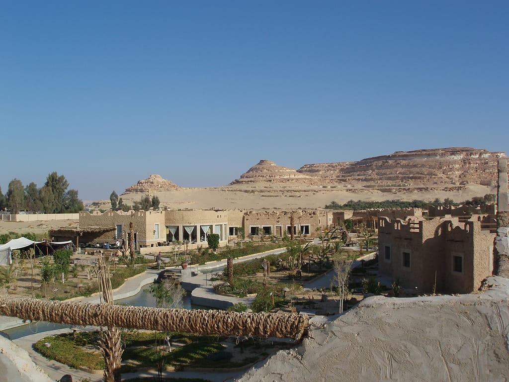 Egypt Eclipse Tour an Hotel in an Oasis with with a mesa behind it