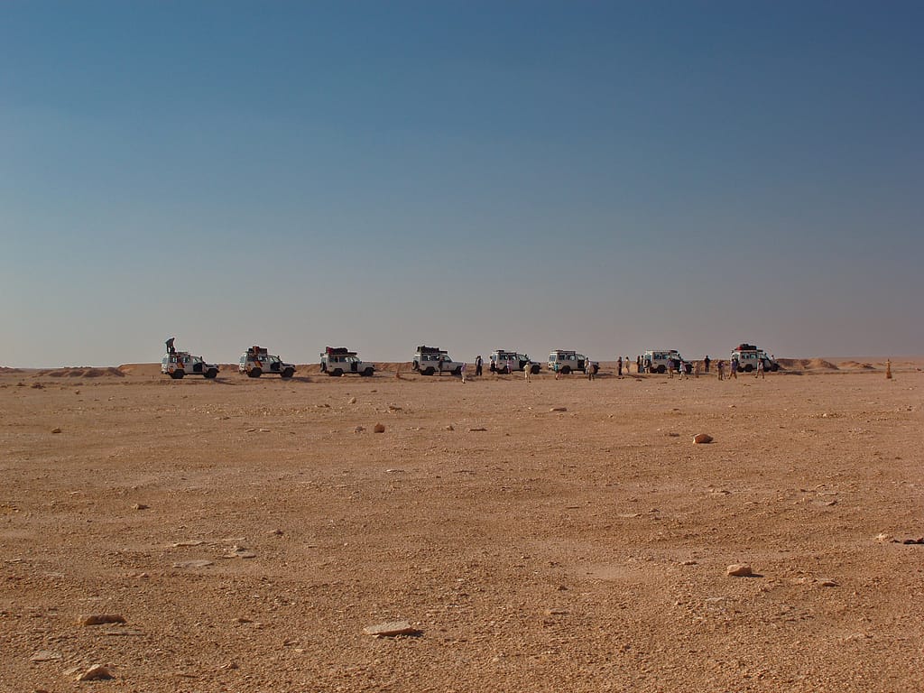 Egypt Eclipse Tour a group of vehicles in a desert